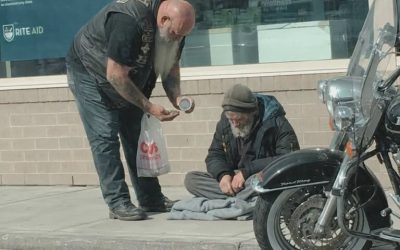 Ich habe einen Motorradfahrer gefilmt, der einem Obdachlosen Geld abnahm und dann hineinging.
